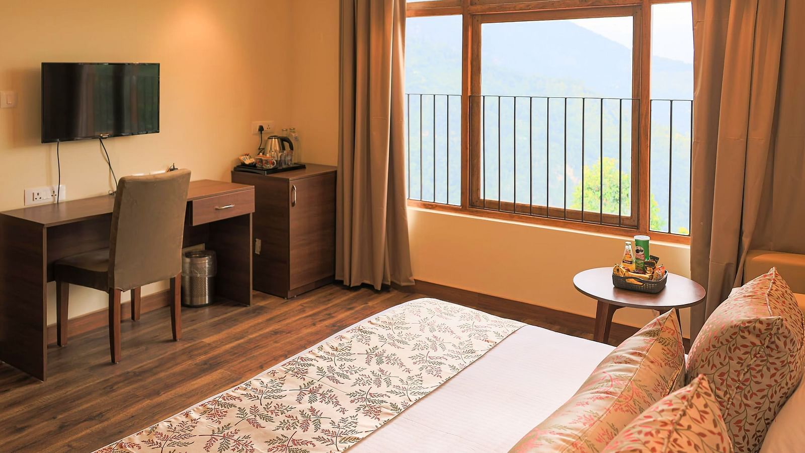 a Premier Room featuring a queen size bed and a wall mounted television at Yashshree Karbari Resort & Spa, Yangang 