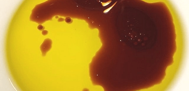 Sauce drizzled with a darker red sauce on a white plate.