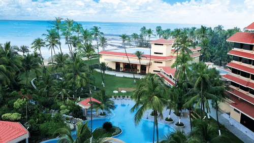 An aerial view of The Retreat Hotel and Convention Centre, with pool, buildings, and palm trees.