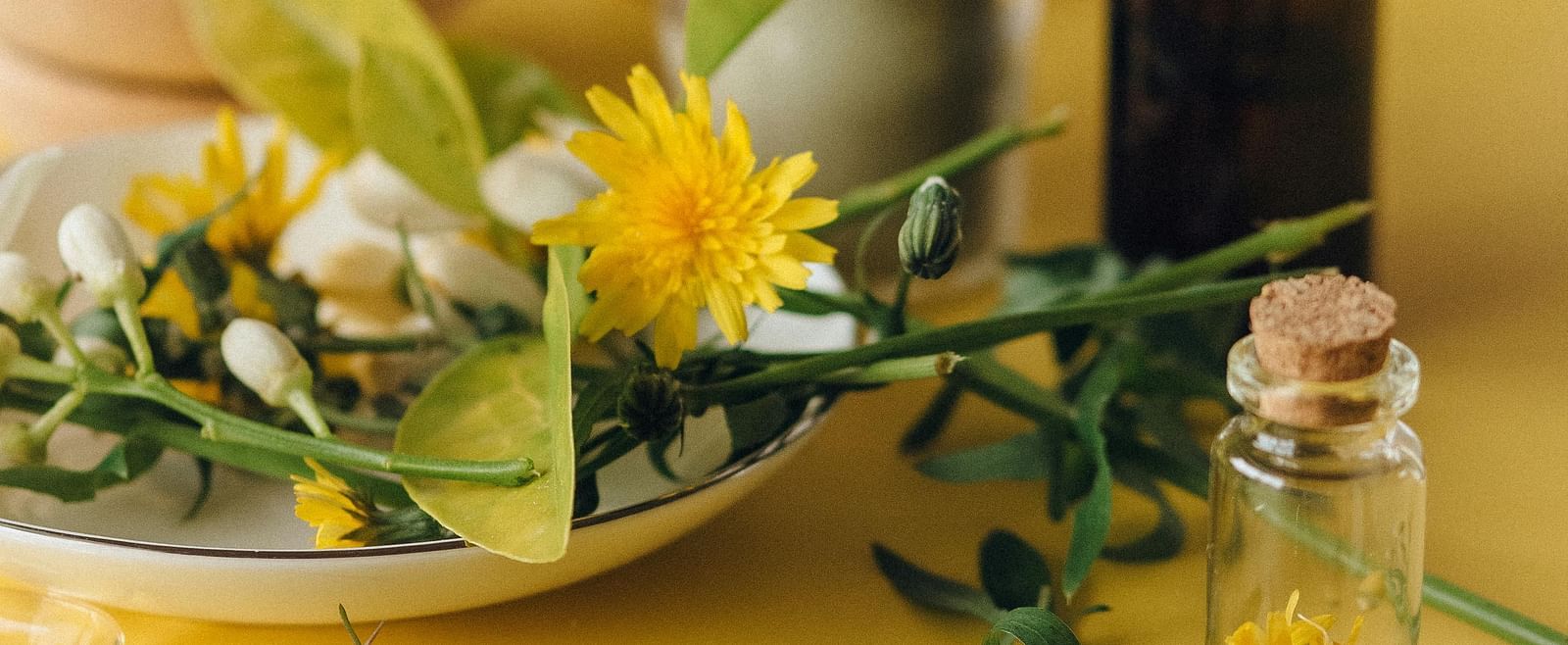 Image of essential oil and flowers kept on the table.