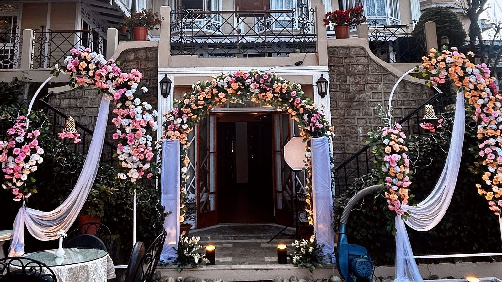 Wedding celebrations at Cedar Inn, Darjeeling, highlighting outdoor seating and traditional decor in front of the hotel façade.