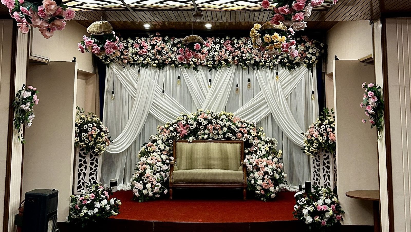 Floral ceiling decor with backdrop setup for wedding ceremony at Cedar Inn, Darjeeling, in an indoor event space.