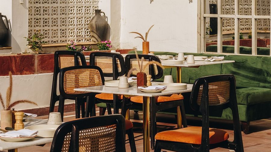 An outdoor dining area with tables and chairs at Surpura Bagh.