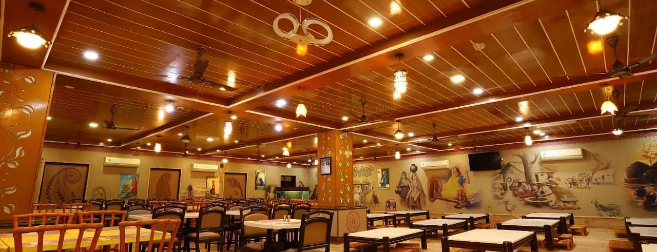 Restaurants fully furnished with wooden tables and chairs with warm lighting.