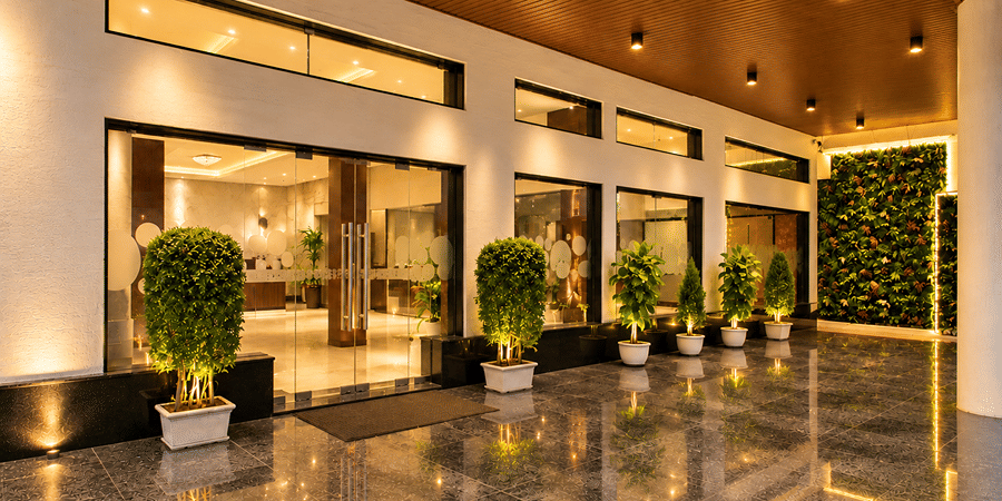 Polished indoor entrance hallway with glossy flooring and potted plants at Bhavani's Vista By Icon, Hosur.   