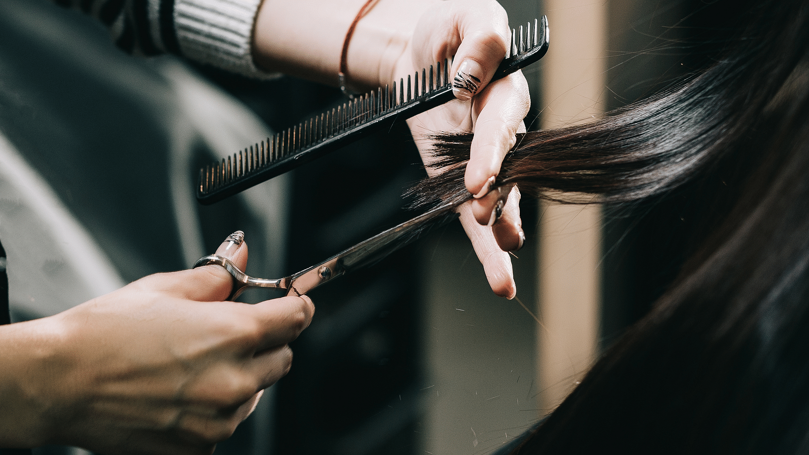 Image of a woman getting a haircut by a stylist
