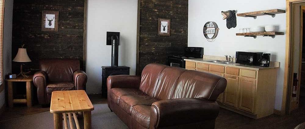 A room at Shaver Lake Village Hotel with a double sofa placed in the center of the room with a wooden coffee table placed in front of it.