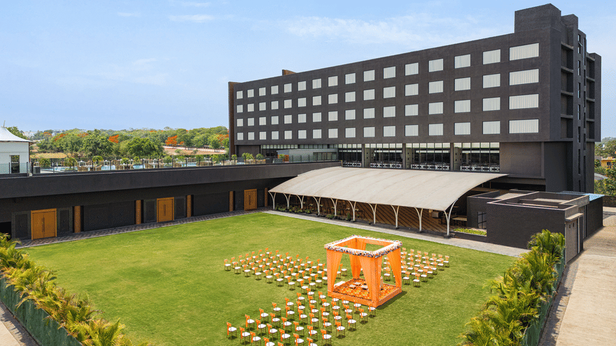 Wedding arrangement in Gulmohar Lawn on a sunny day featuring the facade of Essentia Luxury Hotel, one of the best wedding destinations in Indore 