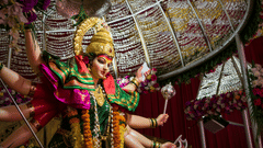 A close up shot of the idol Durga Maa inside a temple with the roof in view