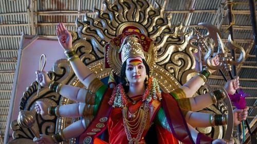 A close up shot of the idol of Durga Maa with the roof in view