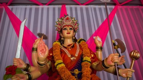 A close up shot of the idol of Durga Maa with the curtain in view