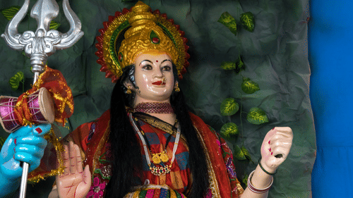 An overview of the goddess Parvati with a crown on her head alongside god Shiva next to her.