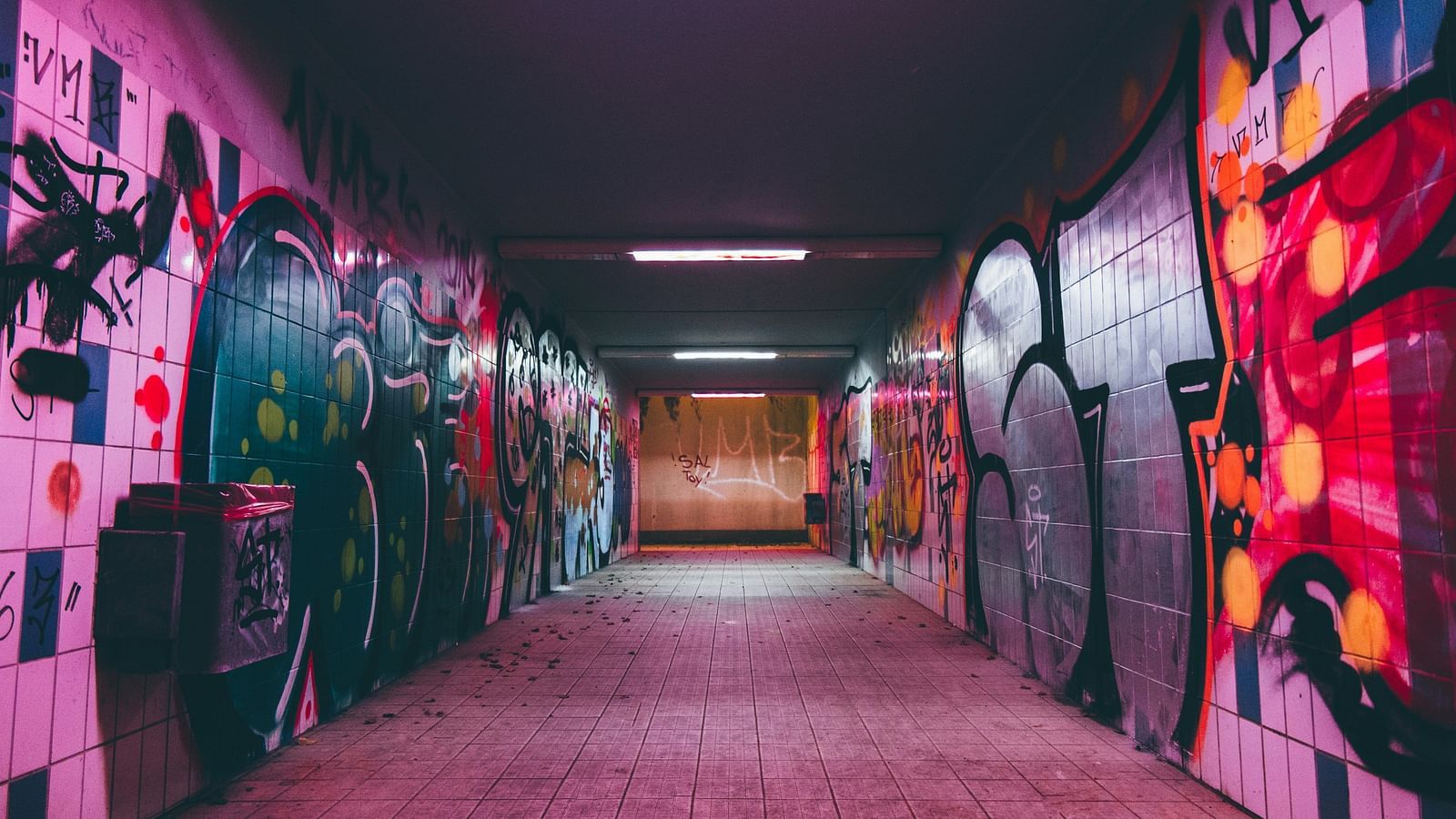 An overview of a corridor with street art on both sides with the light on the roof switched on.