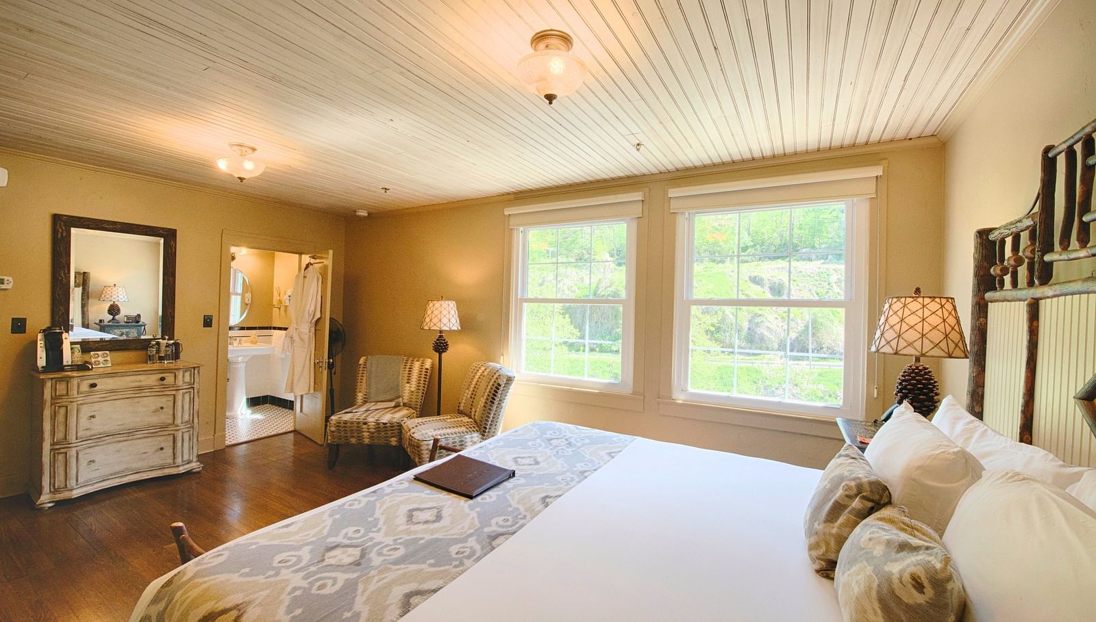 a bright bedroom with ample of natural light coming form the windows beside the double bed - Historic Tapoco Lodge