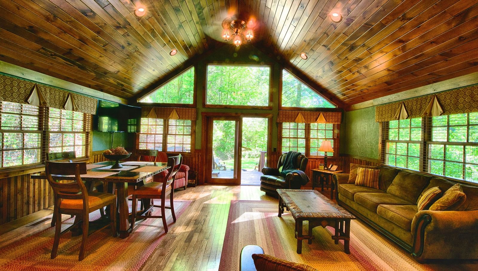a living room with ample seating area featuring huge windows with wooden flooring and ceiling - Historic Tapoco Lodge
