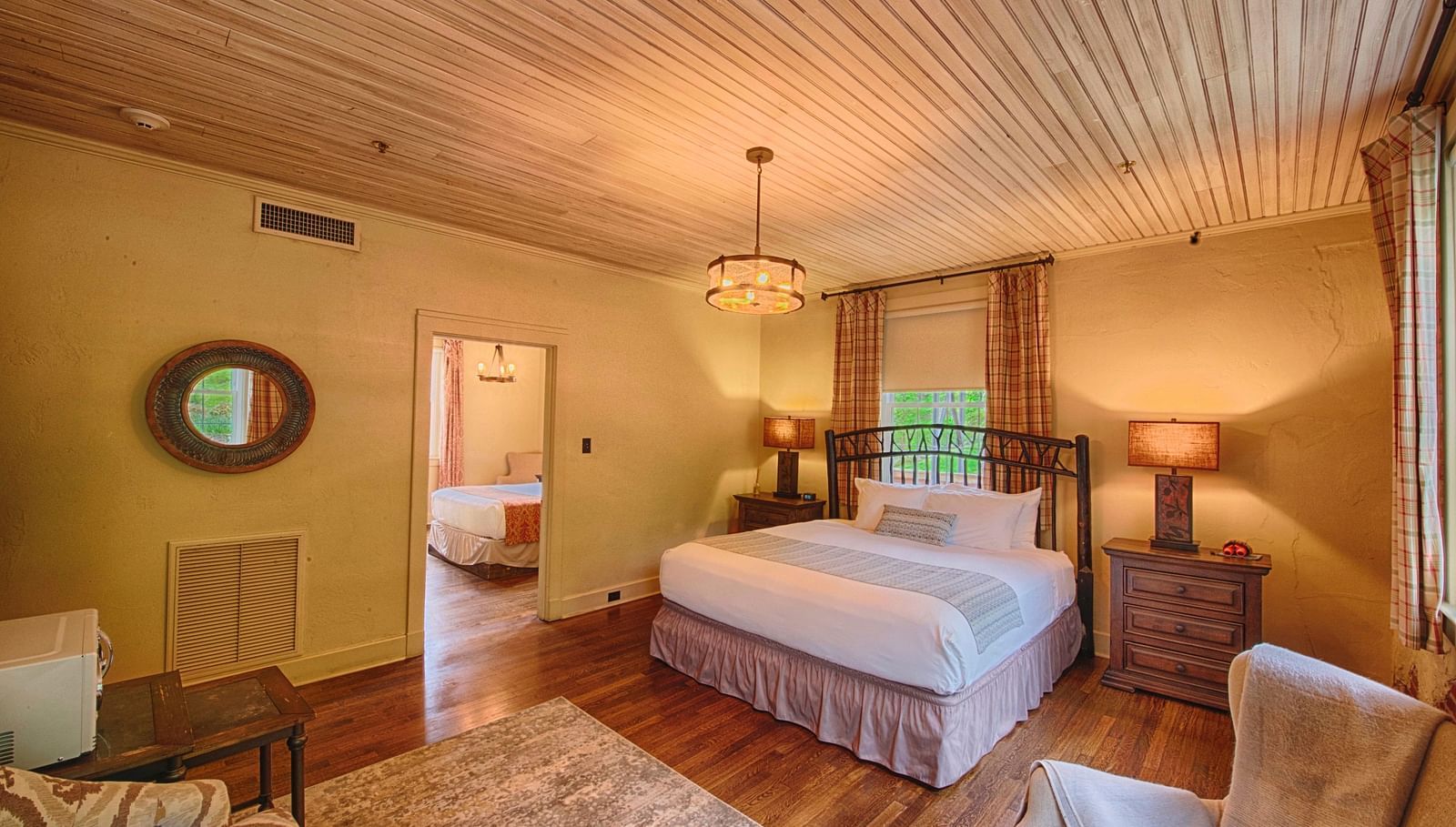 full view image of the evergreen suite featuring a double bed and a small window behind it - Historic Tapoco Lodge