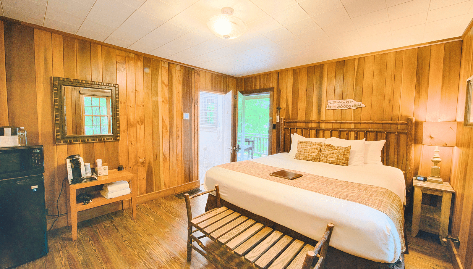 a brightly lit bedroom with the entrance door right besides the double bed with ample natural light - Historic Tapoco Lodge