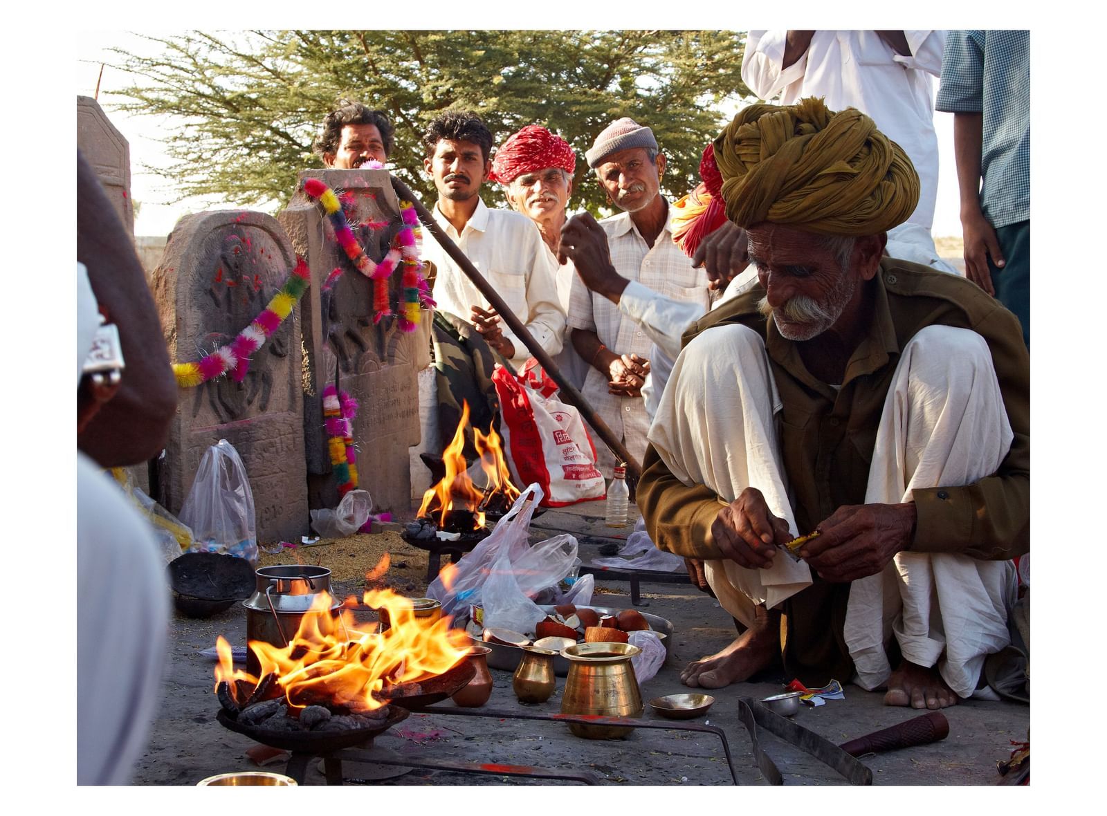 Local villagers cooking food in the open with a makeshift fire