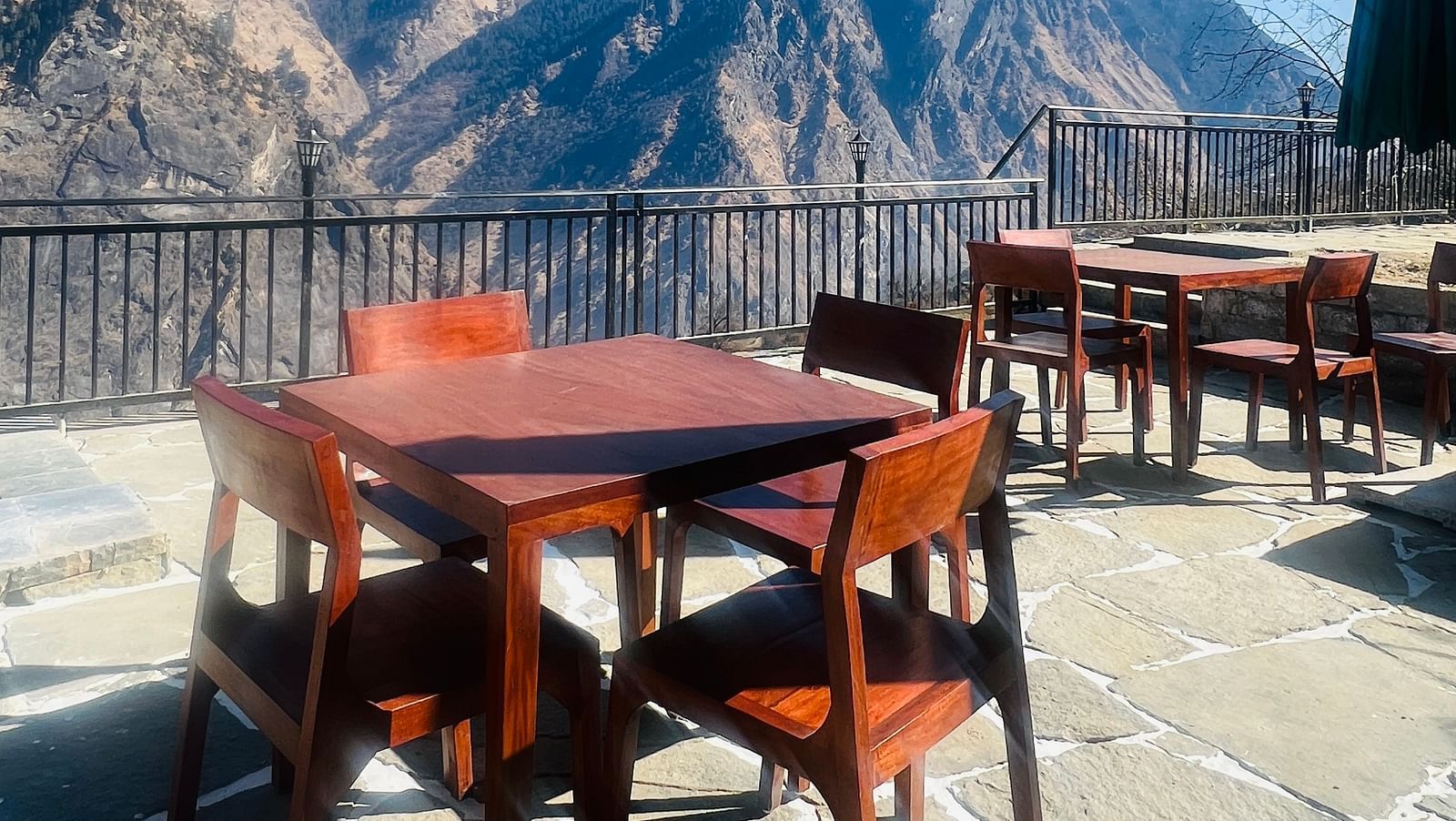 Image of a dining space in a balcony with views of the mountains in the background | Faraway Cottages, Auli