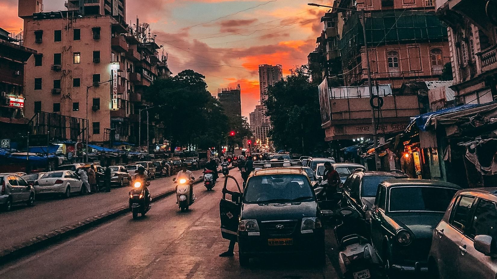 an image of a street in the evening featuring vehicles and building