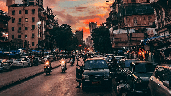 an image of a street in the evening featuring vehicles and building