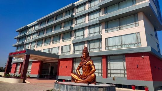An image of the enormous hotel with lord shiva statue at the front 