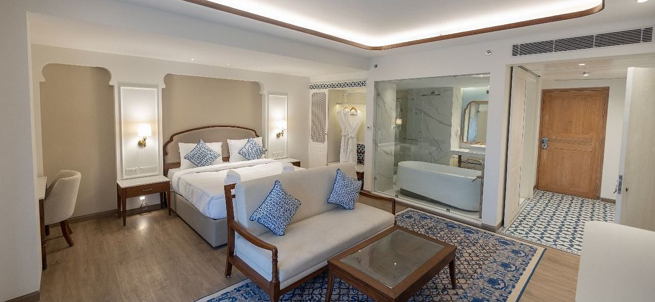 Full view shot of the Purna Room at Bhagirathi by RDB Atishay featuring a double bed and a couch in front of it at Bhagirathi by RDB Atishay. 