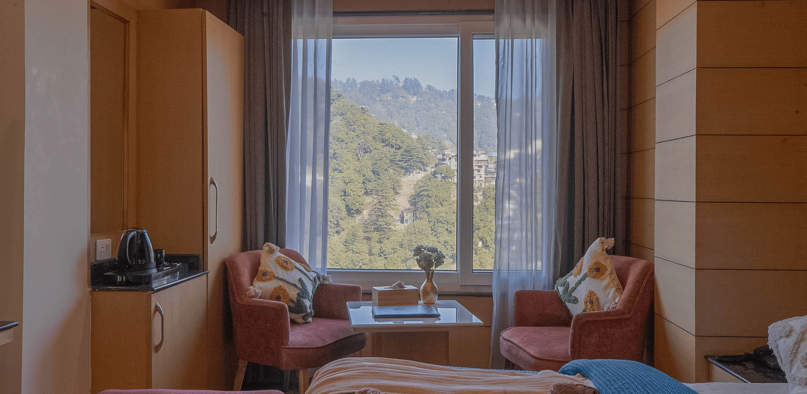 A seating area with chairs, table, and window view at Perfectstayz Premium at Mall Road Hotel Super, Mussoorie.
