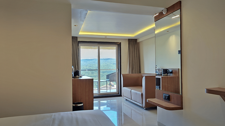 Bedroom with a double bed, wooden furnishings, and glass doors opening to a balcony