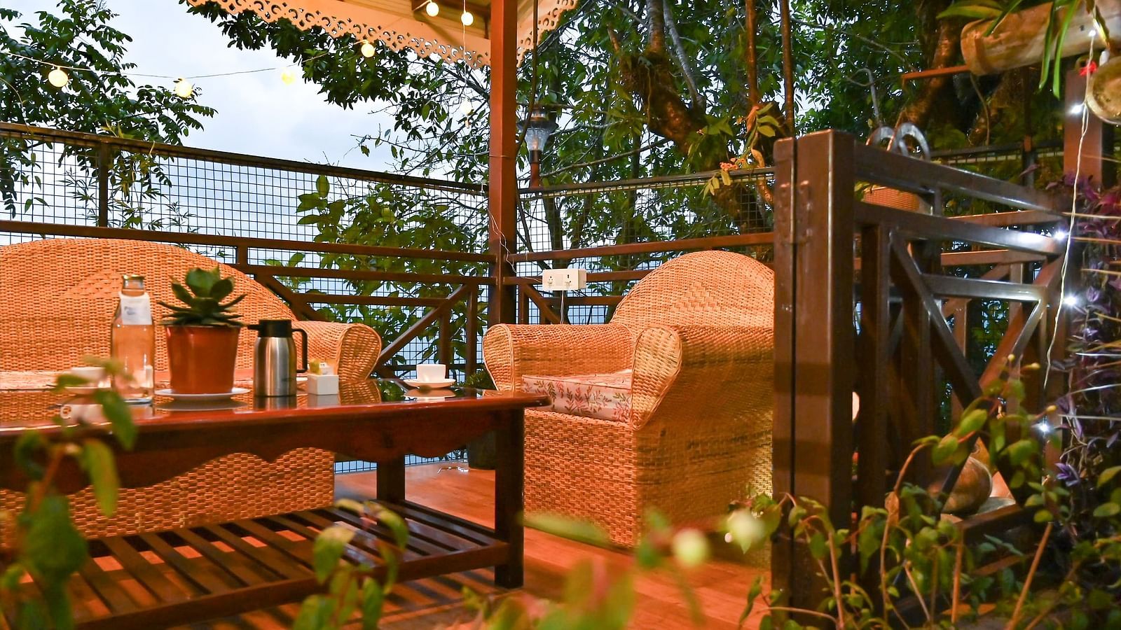 a beautiful garden at Yashshree Karbari Resort & Spa, Yangang during the evening with a cream coloured couch set and a centre table