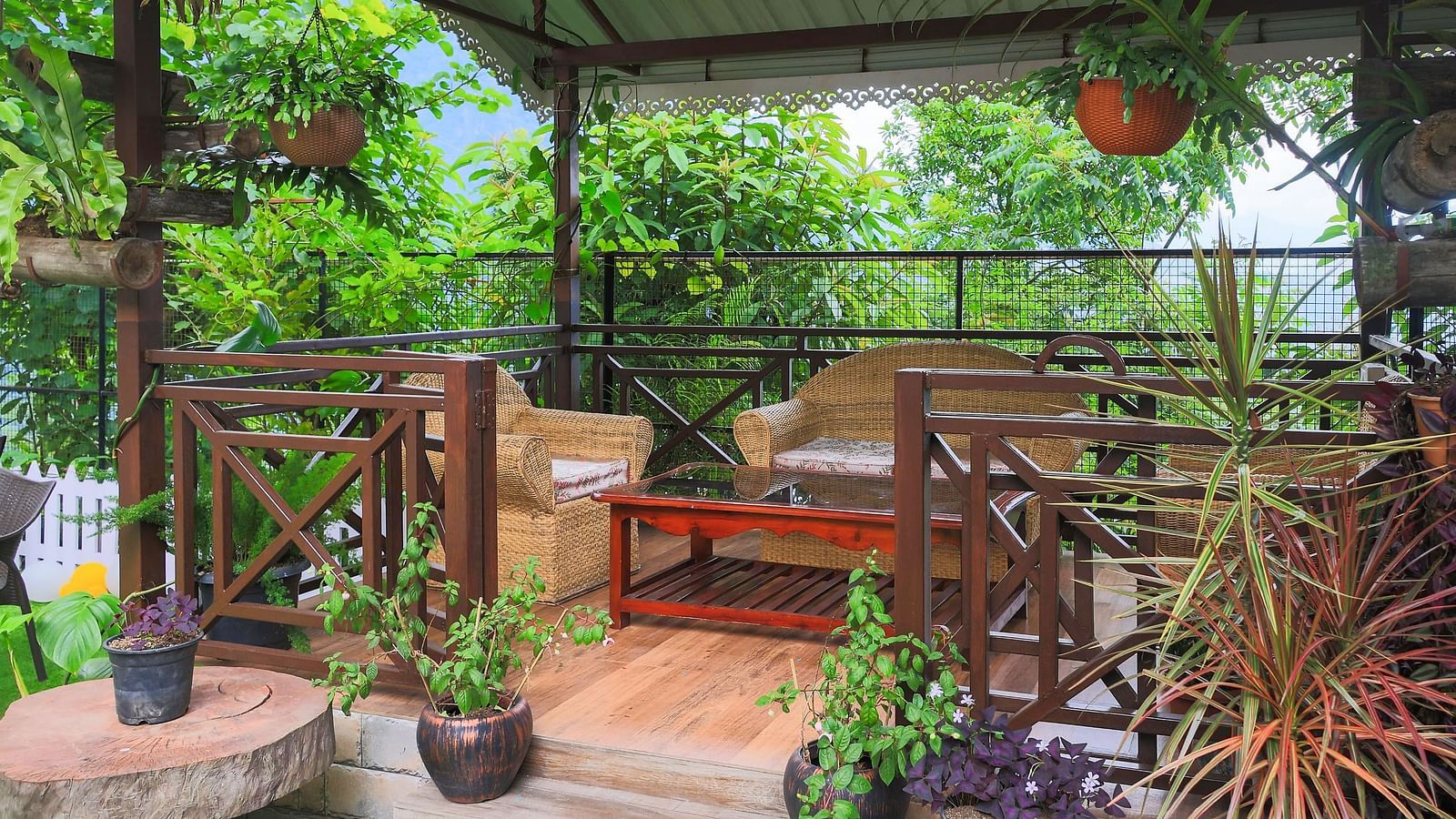 a porch in the garden area of Yashshree Karbari Resort & Spa, Yangang surrounded with lush green plants