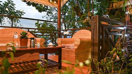 a beautiful garden at Yashshree Karbari Resort & Spa, Yangang during the evening with a cream coloured couch set and a centre table