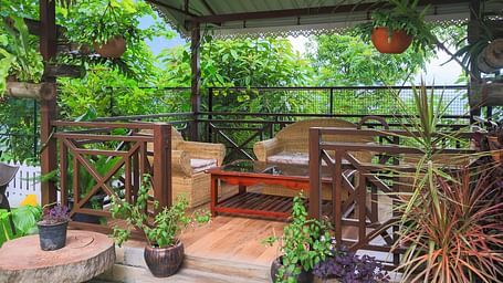 a porch in the garden area of Yashshree Karbari Resort & Spa, Yangang surrounded with lush green plants