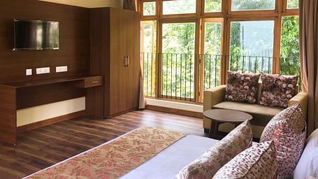 full view image of the Premier room with balcony at Yashshree Karbari Resort & Spa, Yangang with beautiful views outside the balcony