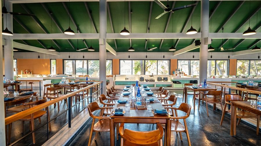 Central seating layout inside Song of the Sea with wooden tables and chairs.