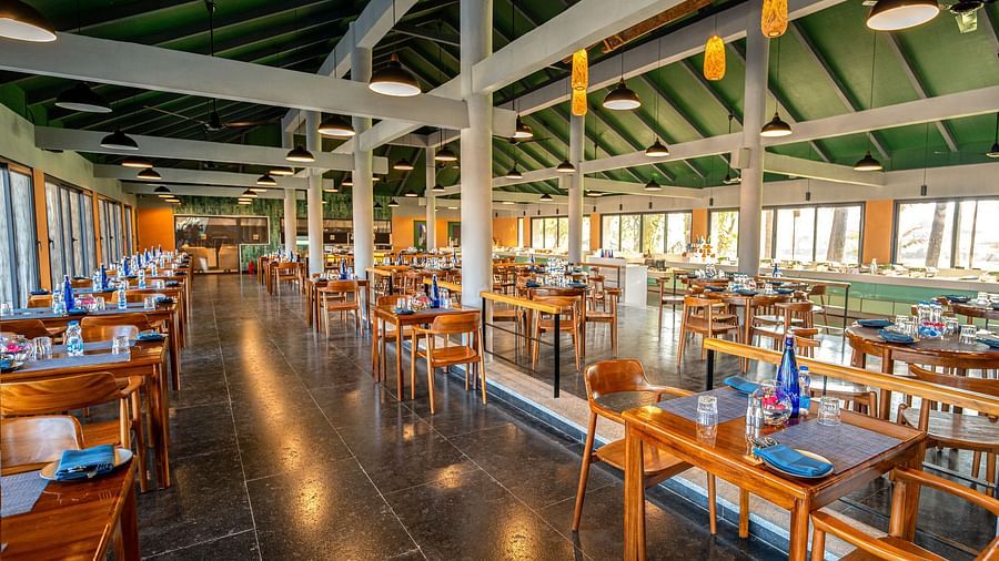 Wide-angle view of the dining area with multiple tables and chairs inside Song of the Sea restaurant.