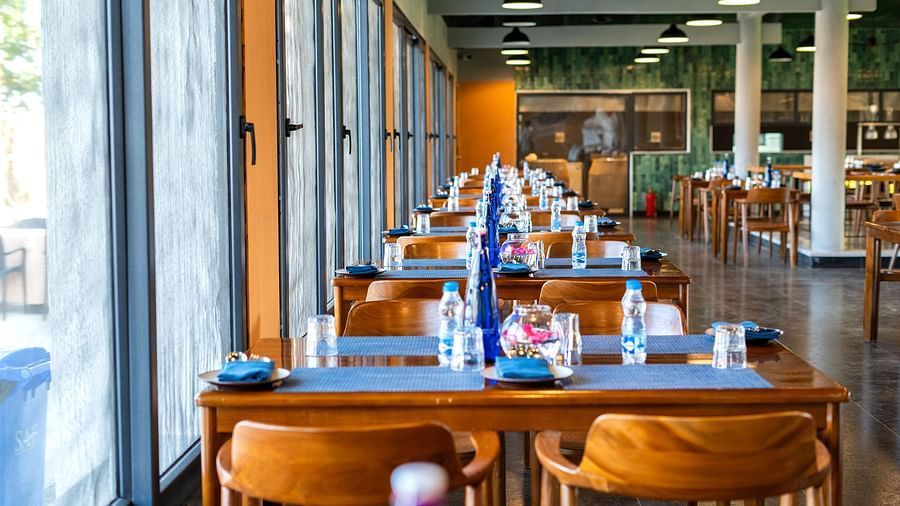 Row of set tables inside Song of the Sea restaurant with glass windows.