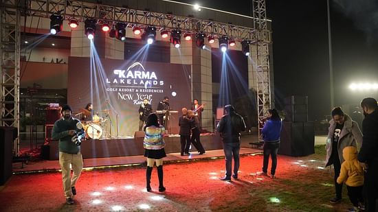 image showing a stage with red carpet with a few people celebrating new year at karma lakelands
