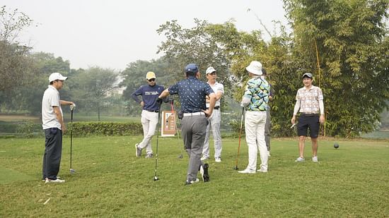 image of a group of people playing golf on a misty morning at karma lakelands