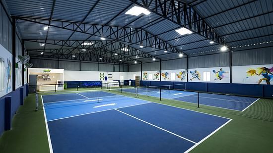 Indoor pickleball courts with blue and green flooring and colourful wall art, located at Jenneys Residency, Coimbatore.