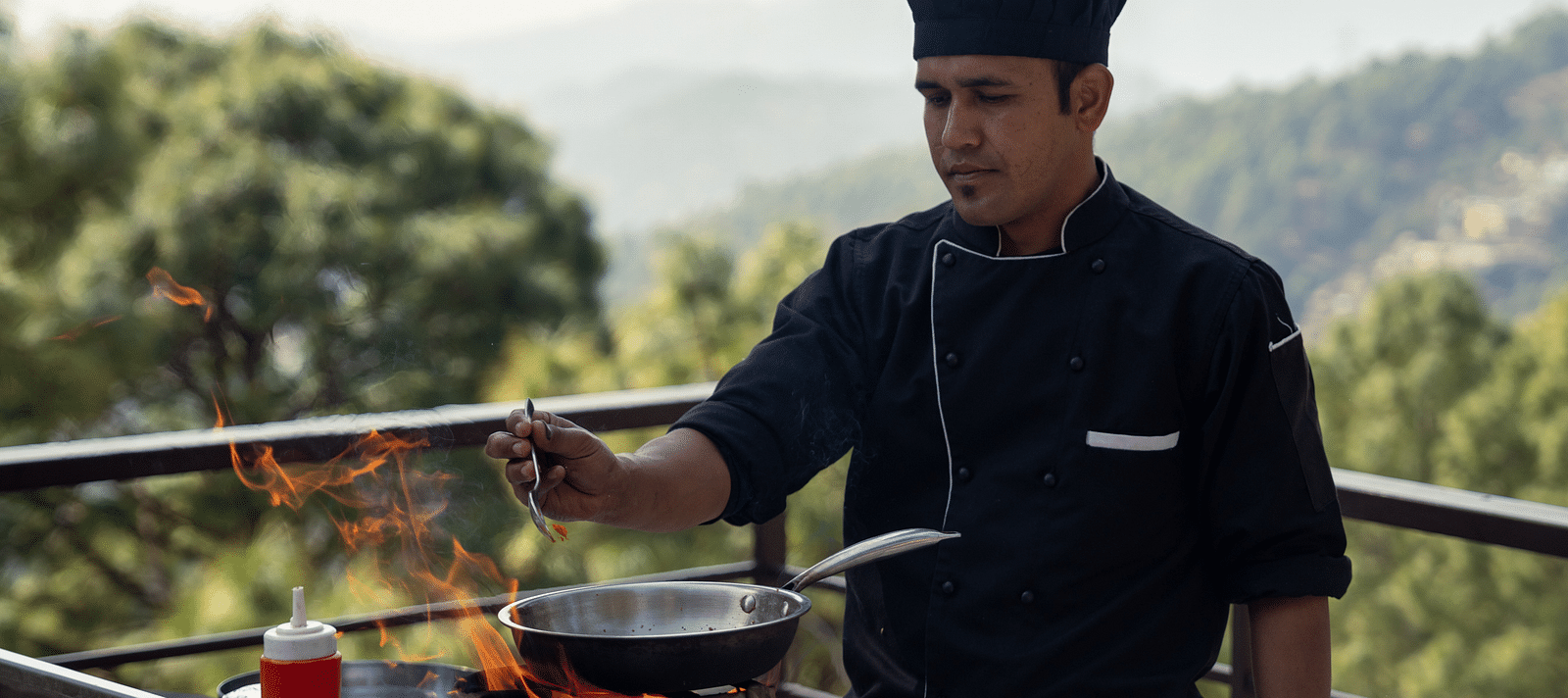 A person grilling barbecue on the terrace at BluSalzz Escapade Resort, Lansdowne