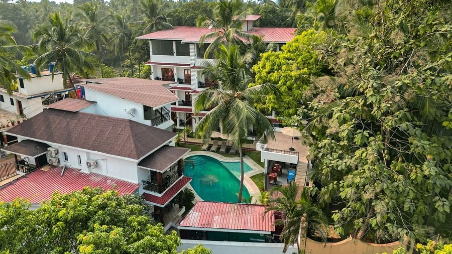 An aerial view of  The Verda de Miranda Resort with a pool nestled among palm trees.