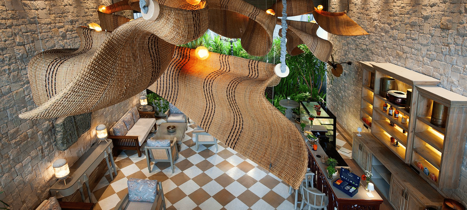 A top-angle shot featuring the unique chandelier hanging from the ceiling above the Suenos de Cafe at The Evren, Vagator.