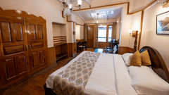 Side view of the Heritage Room with a cozy bed at Himalaya Hotel, Nainital