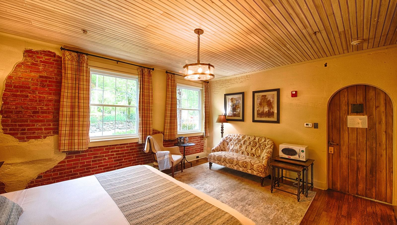 corner view image of a room featuring an arched wooden door with chic modern interiors - Historic Tapoco Lodge
