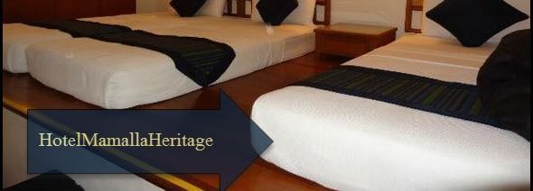 A bedroom with twin beds and a single bed, side tables, lamps, a cabinet and wall decor with the text 'Hotel Mamallaa Heritage.'