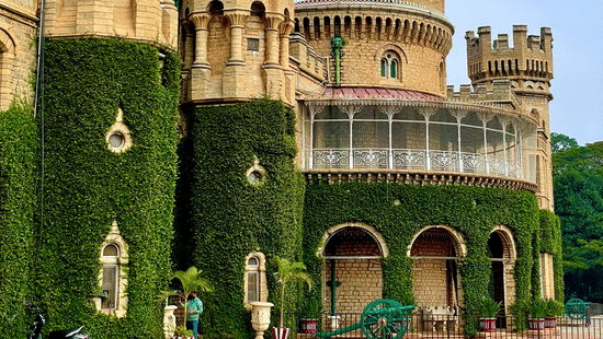 Historic stone palace with towers and arched entrances under a clear sky.