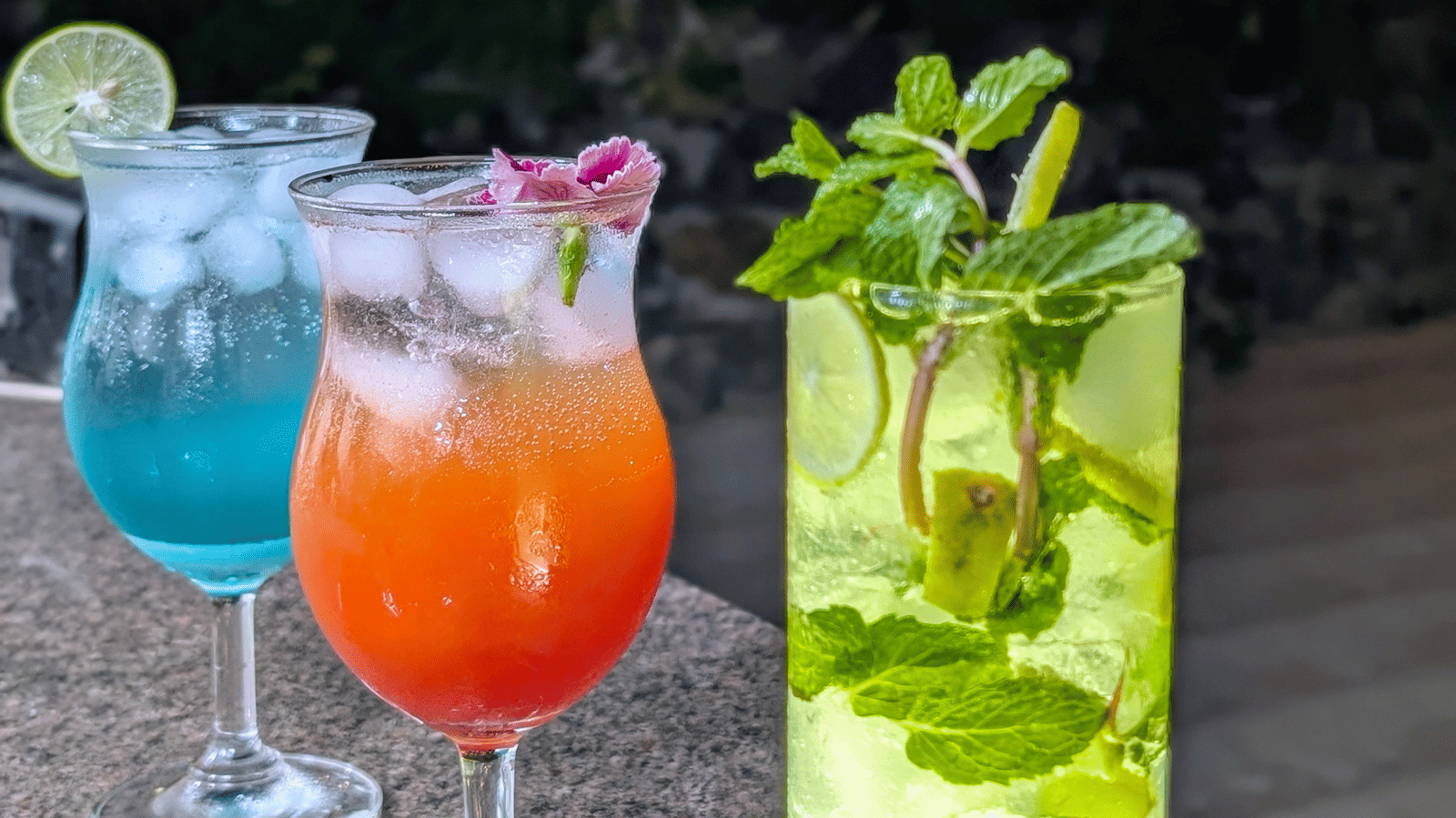 Colourful mocktails at Dip Holidays, served against a warmly lit evening backdrop.