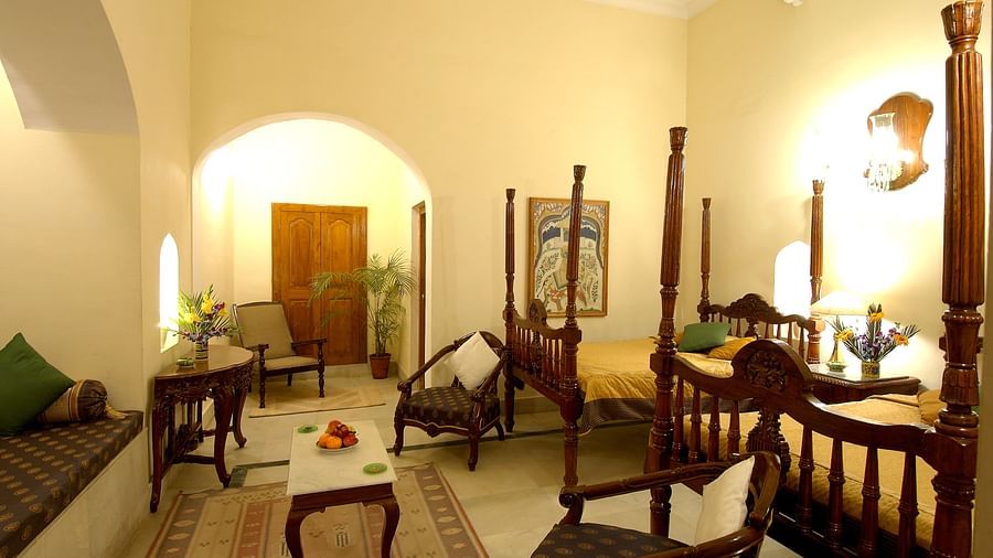 a bedroom with two beds and chairs for sitting - Hotel Castle Mandawa, Jhunjunu