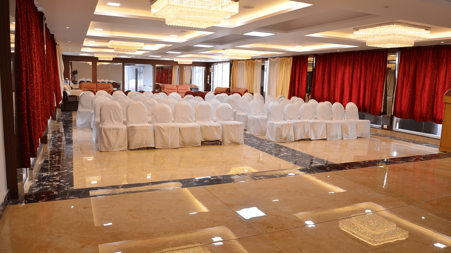 A banquet hall with bright lights and organised seating, perfect for conferences and celebrations - Benzz Park, Kodaikanal